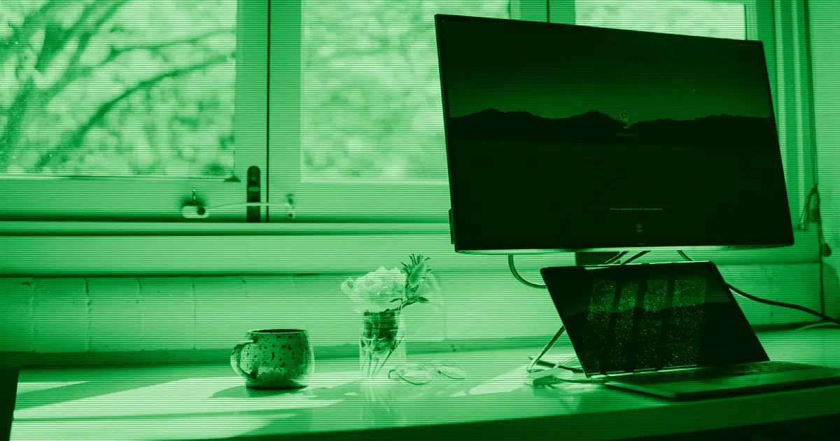 Un portátil y un monitor sobre un escritorio de trabajo