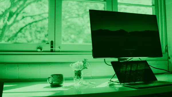 Un portátil y un monitor sobre un escritorio de trabajo