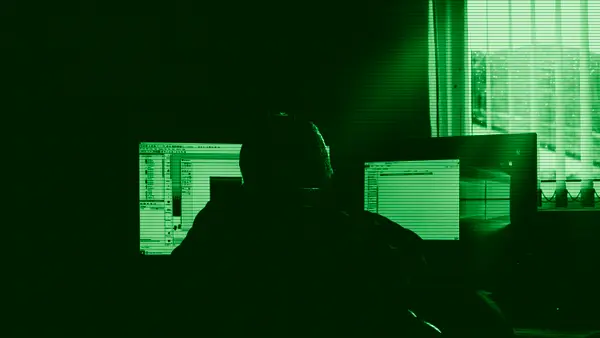 Una persona trabajando frente a varios ordenadores
