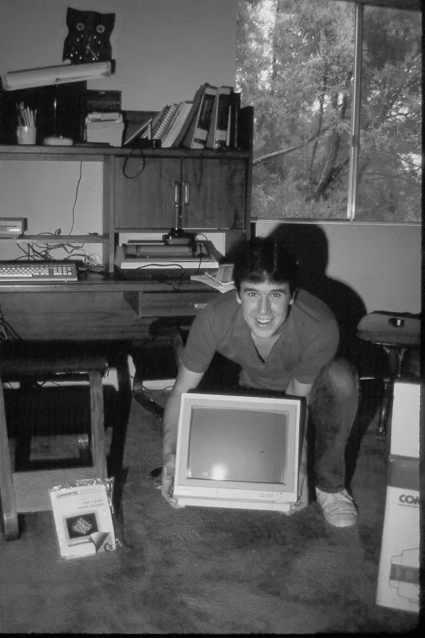 Photograph of programmer Terry A. Davis next to a Commodore 1902A monitor