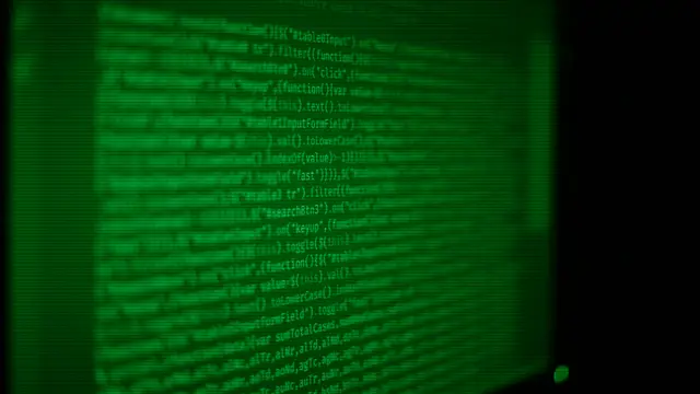 Pantalla con código y un terminal, símbolo del software libre que da origen a las distribuciones de Linux